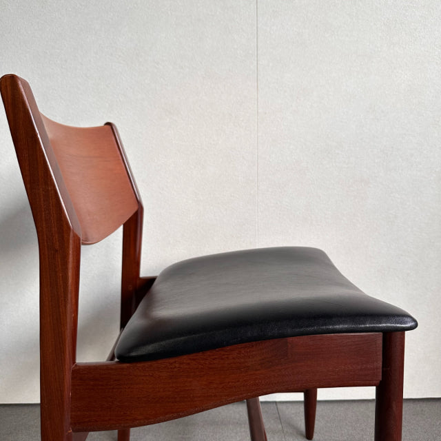 Mid-century British vintage dining chair with warm teak frame and smooth black leather seat, showcasing rich wood grain and.