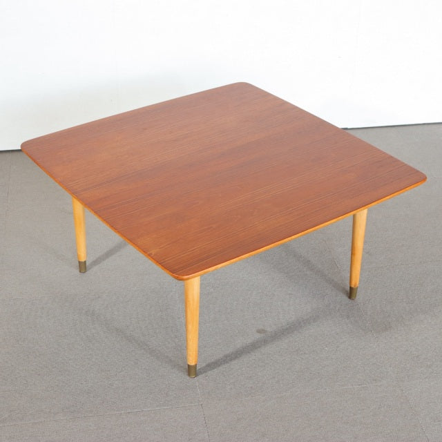 Square vintage teak coffee table with rounded edges, mid-century British design, slender legs with brass caps.