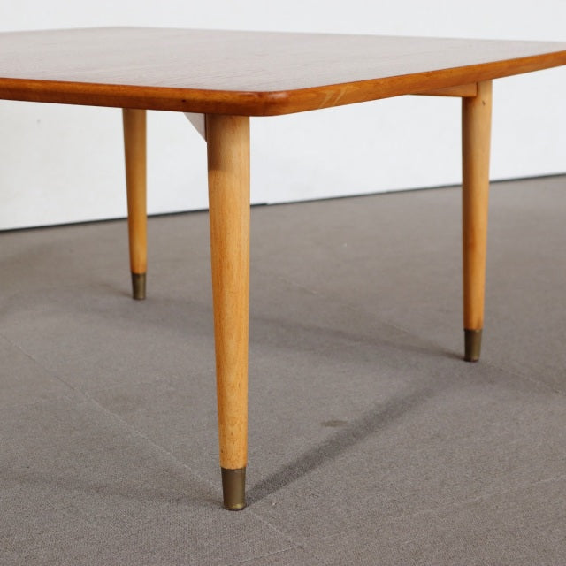 Mid-century vintage teak coffee table with rounded edges, slender tapered legs, and brass-capped feet, showcasing British.