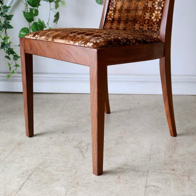 Set of four G-Plan vintage mid-century teak dining chairs with British design, tapered legs, and patterned upholstery.