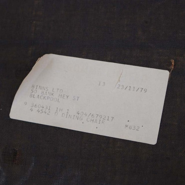 Vintage teak wooden dining chair label with printed product details and date markings.