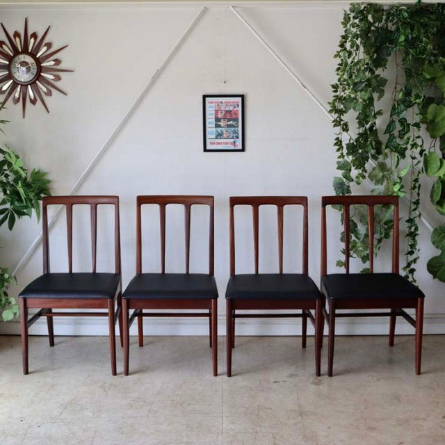 Set of four vintage mid-century teak dining chairs by A.Younger Ltd., British design with slim vertical slat backs and black .