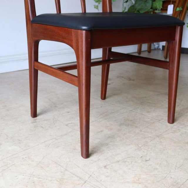 Vintage teak dining chair with sleek British mid-century design, smooth wood grain, and black cushioned seat showcasing.