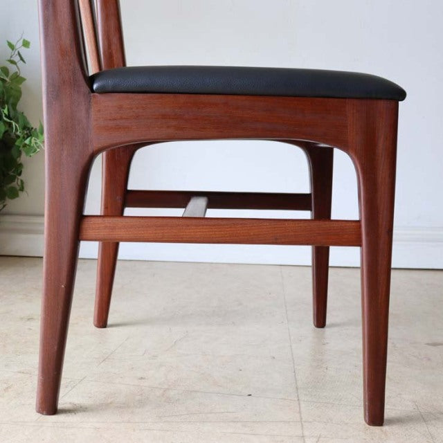 Set of four A.Younger Ltd. dining chairs with vintage teak frames, black cushioned seats, sleek British mid-century design,.