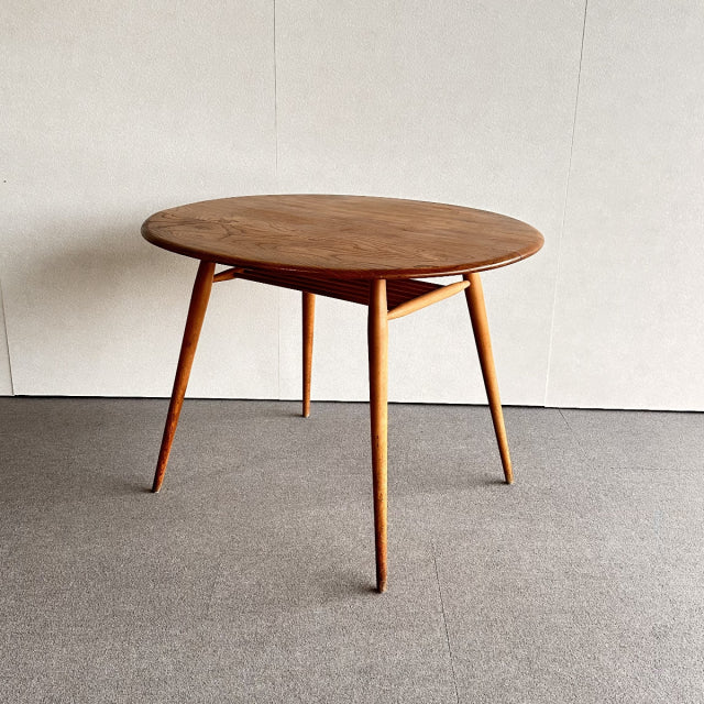 Vintage mid-century ERCOL teak breakfast table with round top, tapered legs, British and Danish design influence.