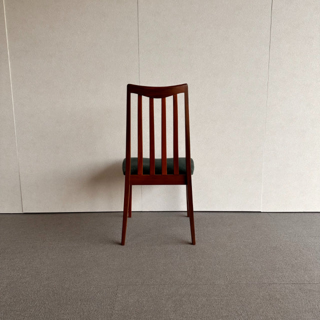 Mid-century British G-PLAN dining chair with vintage teak frame and vertical slat backrest, dark upholstered seat, and.