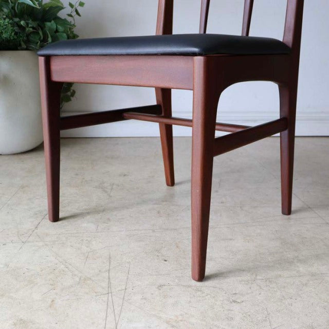 Vintage teak dining chair with sleek tapered legs, black upholstered seat, and mid-century British-Denmark design.