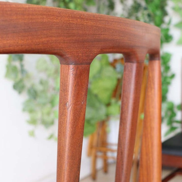 Mid-century British teak dining chair backrest and legs showcasing smooth wood grain and elegant vintage craftsmanship.