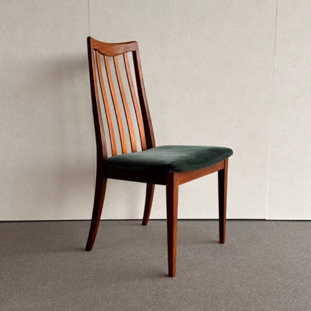 Mid-century British G-PLAN dining chair with teak frame and dark upholstered seat, featuring curved slatted backrest and.