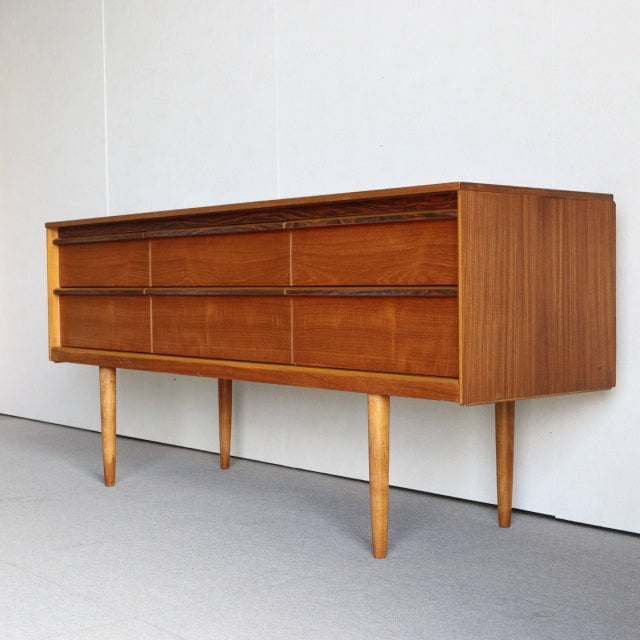 Vintage British mid-century Austinsuite teak sideboard with rich wood grain, six drawers, and slender tapered legs from.