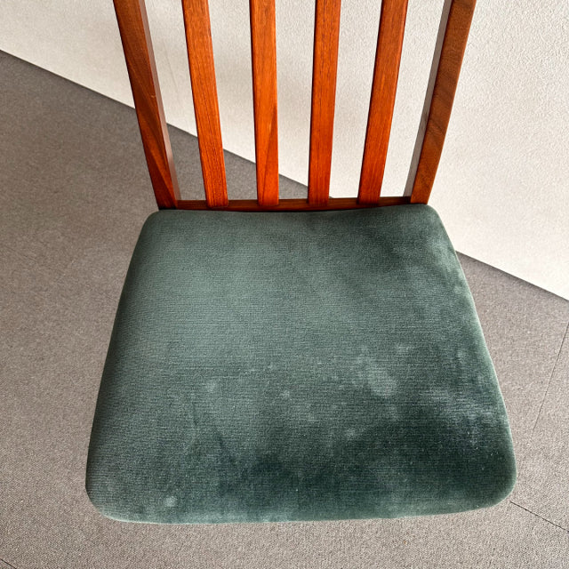 Mid-century British G-PLAN dining chair with teak slatted back and plush dark green velvet seat cushion showing slight wear.