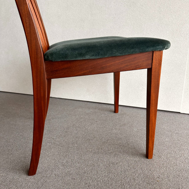 Mid-century British G-Plan dining chair with teak frame and dark green velvet upholstered seat, showcasing wood grain and.