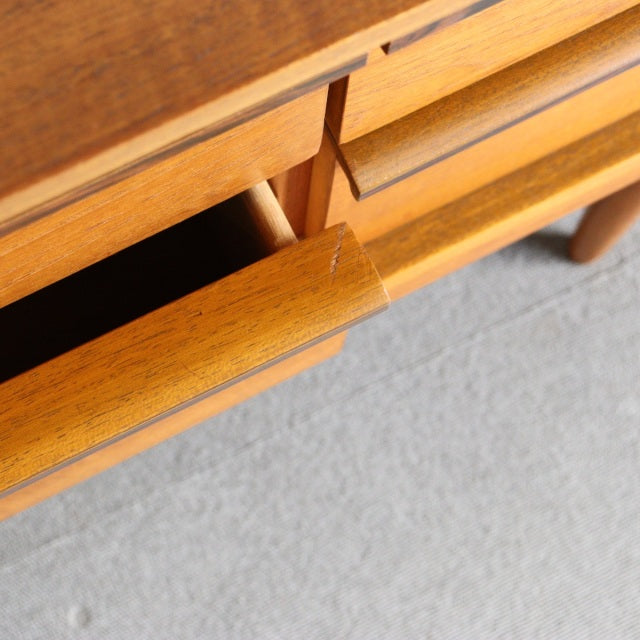 Mid-century British teak sideboard by Austinsuite with smooth wood grain and rounded drawer handles.
