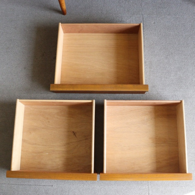 Three vintage teak drawers with visible wood grain and clean mid-century lines, part of a British-Denmark style Austinsuite.