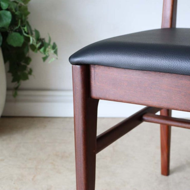 Vintage teak dining chair with black leather seat, British mid-century design, sleek wood grain and tapered legs from.