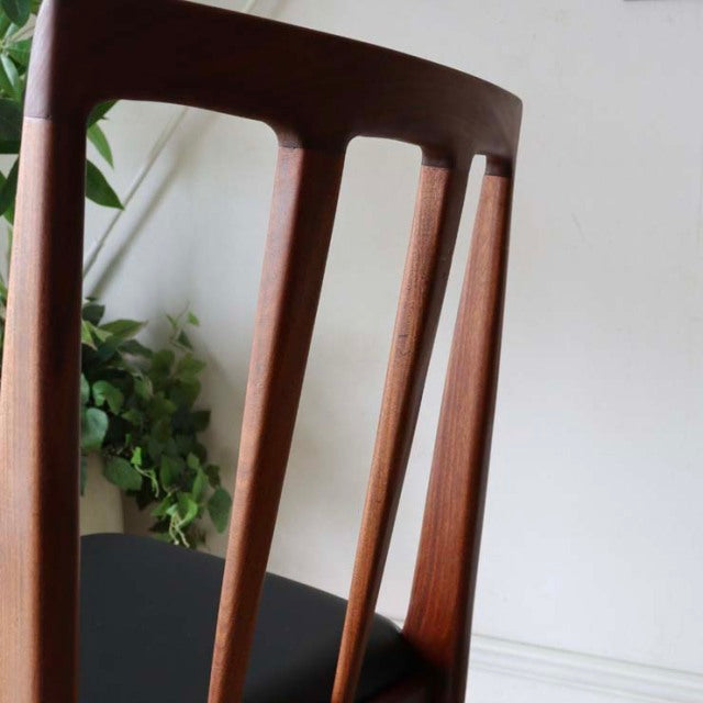 Vintage teak dining chair with slender tapered legs and curved backrest, British mid-century Denmark design.