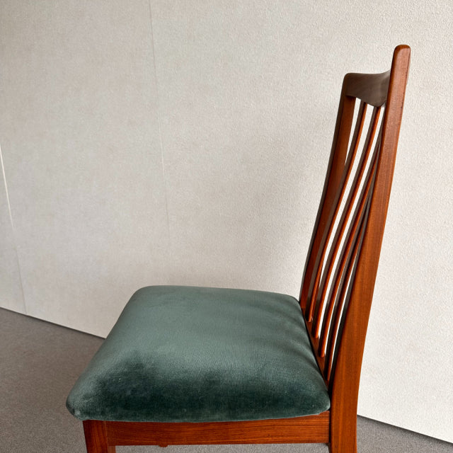 Vintage British G-Plan dining chair with teak frame, curved slatted backrest, and green velvet seat from mid-century Denmark .