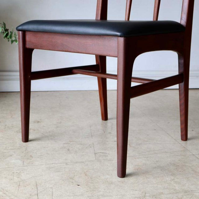 Set of four mid-century British dining chairs by A.Younger Ltd., teak wood frames with visible grain and black upholstered.