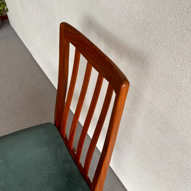 Mid-century British G-Plan dining chair with teak slatted backrest and green upholstered seat, sleek wooden legs, visible.