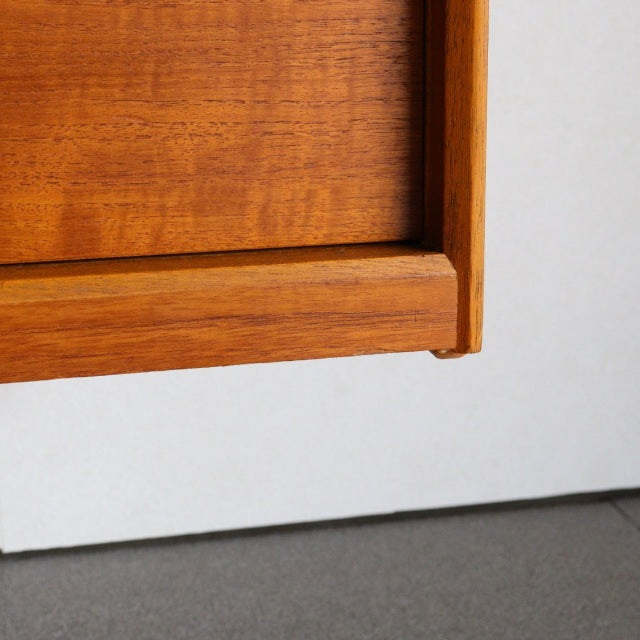 Close-up of vintage Austinsuite teak sideboard corner showing rich wood grain and mid-century British-Denmark craftsmanship.