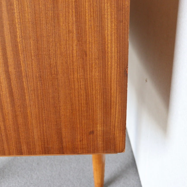 Mid-century British vintage teak sideboard corner showing smooth wood grain and tapered wooden leg from Austinsuite.