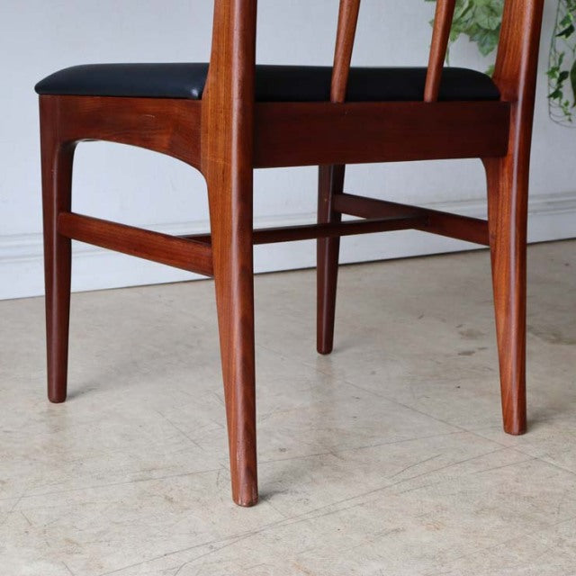 Mid-century British vintage teak dining chair from Denmark with sleek tapered legs and black cushioned seat.