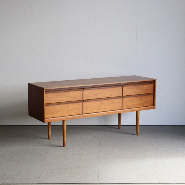 Mid-century vintage teak sideboard by Austinsuite with clean lines, six drawers, slender tapered legs, and warm wood grain.