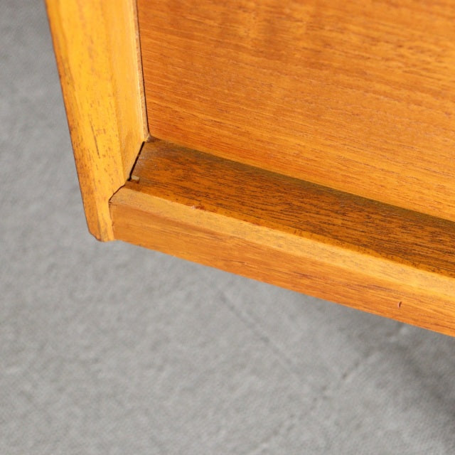 Close-up of vintage Austinsuite teak sideboard corner showing warm wood grain and clean mid-century British craftsmanship.