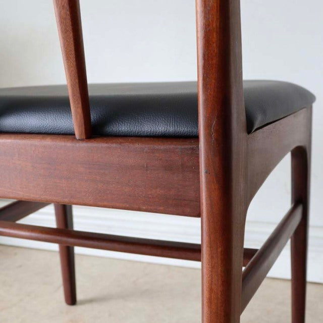 Mid-century British vintage teak dining chair by A.Younger Ltd, black leather seat, slender tapered legs, smooth wood grain.