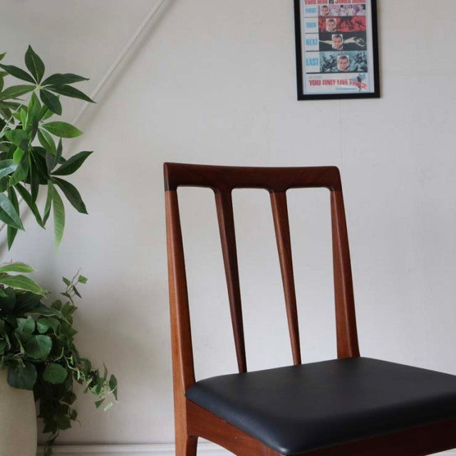 Vintage teak dining chair with British mid-century Danish design, featuring slender vertical slats and black leather seat.