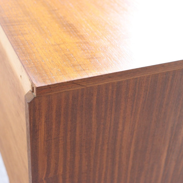 Close-up of vintage mid-century teak sideboard corner showcasing rich wood grain and smooth finish, British-Denmark design.