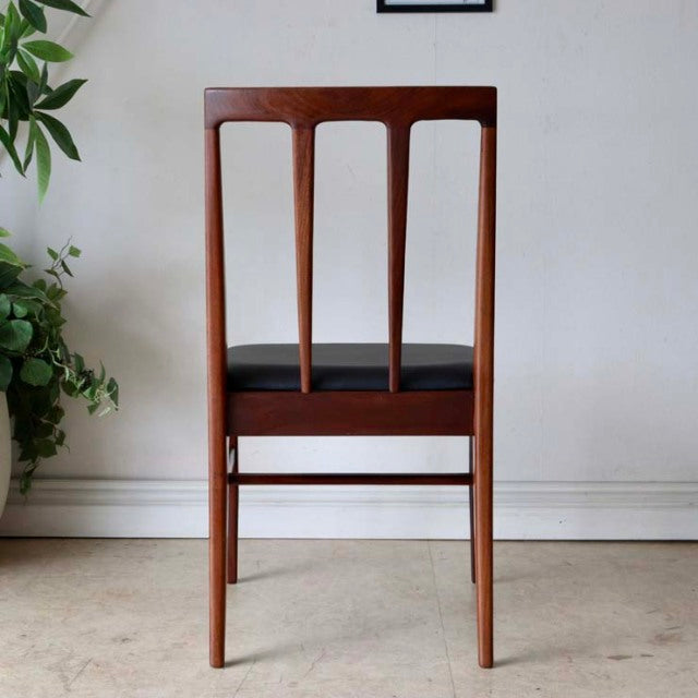 Vintage teak dining chair with British mid-century design, slender vertical slats and smooth wood grain from Denmark.