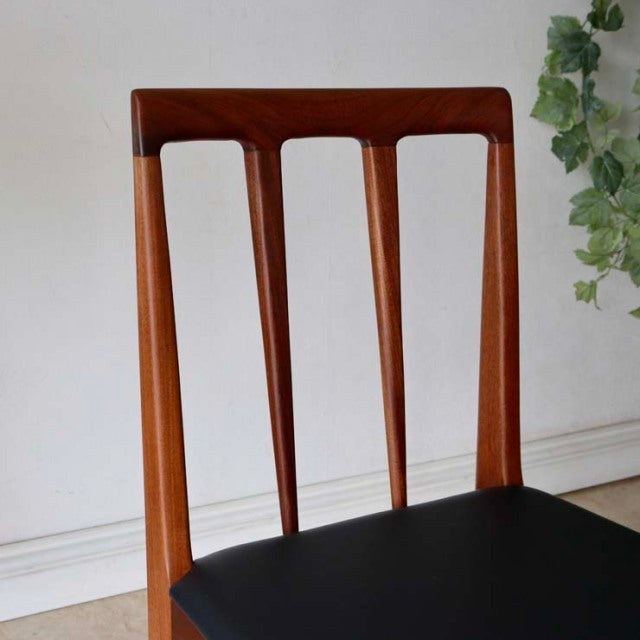 Vintage teak dining chair with British mid-century design, slender vertical slats, and black upholstered seat.