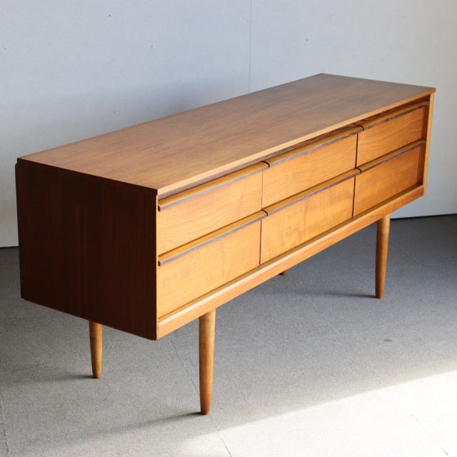 Mid-century British teak sideboard by Austinsuite with eight drawers, sleek wood grain, and tapered legs.