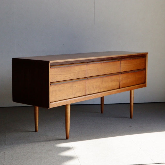 Mid-century vintage British teak sideboard by Austinsuite with six drawers and tapered legs showcasing rich wood grain and.
