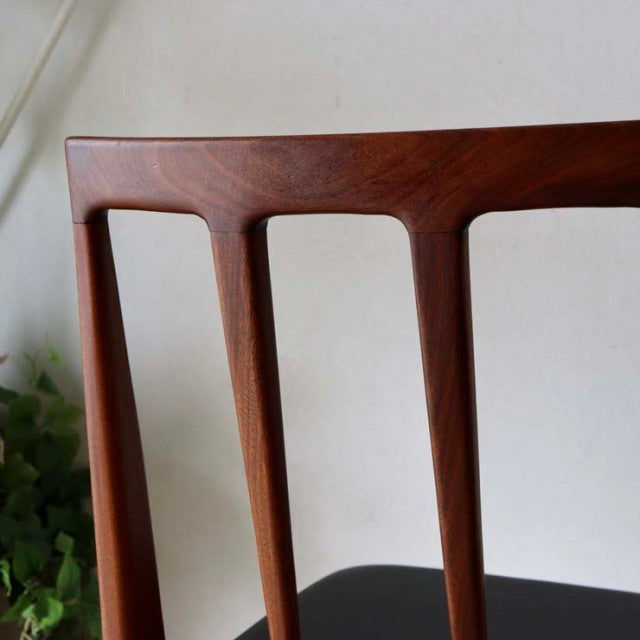 Vintage mid-century teak dining chair backrest with smooth grain and sculpted British-Danish design.