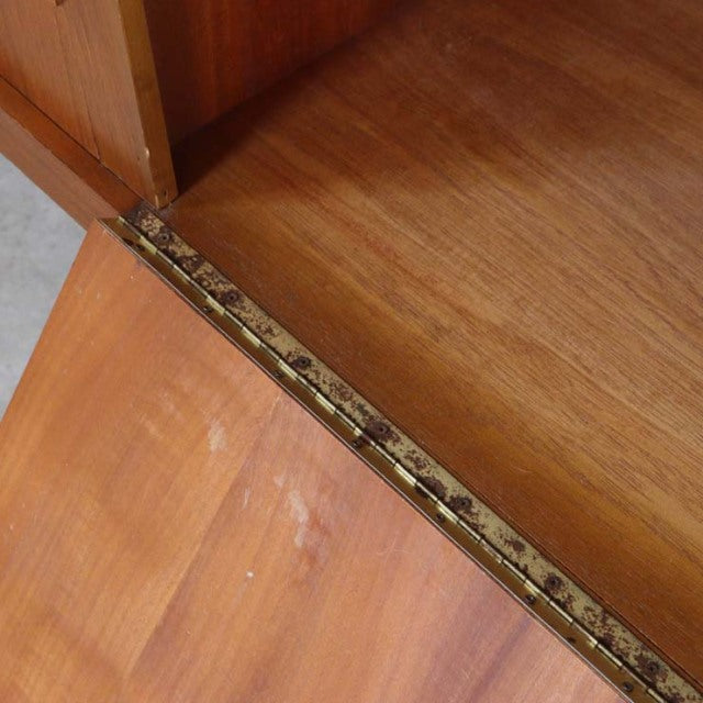 Close-up of vintage mid-century teak sideboard hinge showing fine wood grain and brass hardware from British-Denmark design.