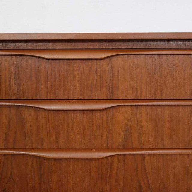 Vintage teak British mid-century sideboard drawer fronts with smooth wood grain and carved recessed handles.