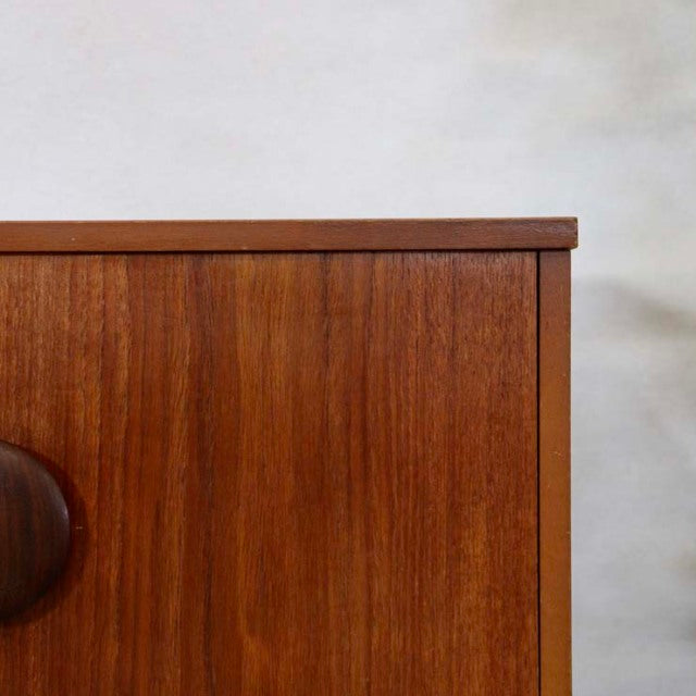 Mid-century British vintage teak sideboard with unique curved legs and rounded wooden handles, rich wood grain detailed.