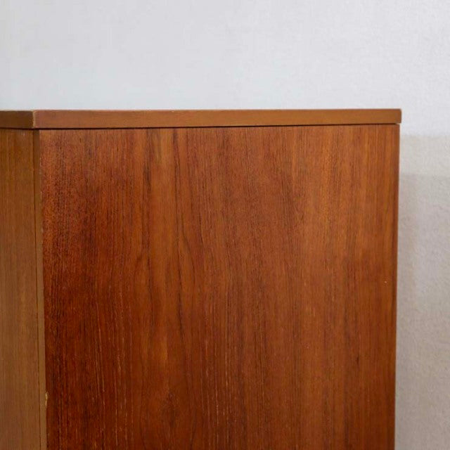 Mid-century British vintage teak sideboard with distinctive wood grain, clean lines, and unique legs and handles.