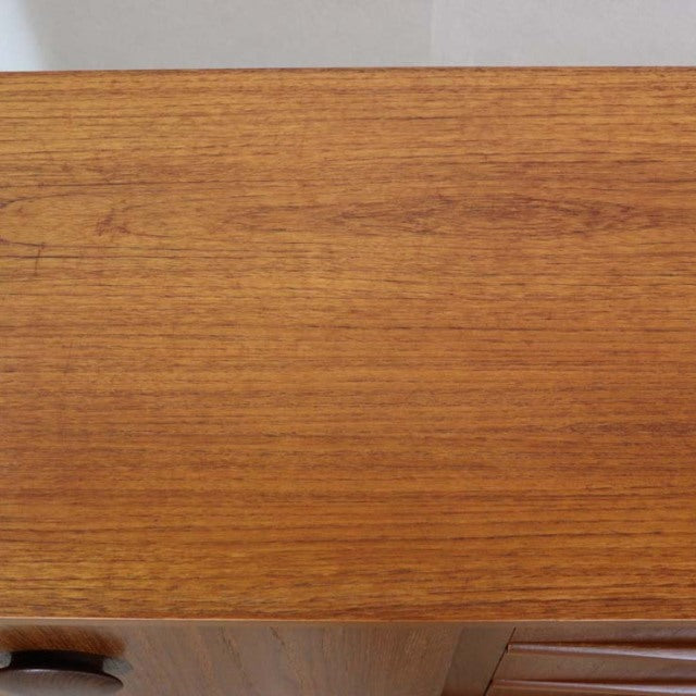Vintage teak mid-century British sideboard top showcasing smooth wood grain and warm honey tones.