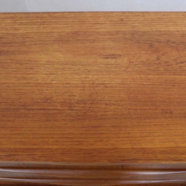 Close-up of vintage teak wood grain on British mid-century sideboard surface with warm natural tones.