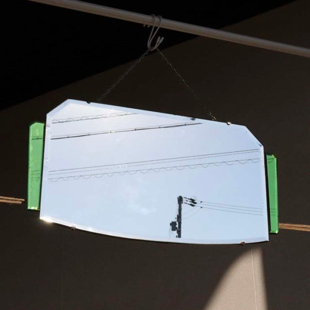 Vintage mid-century British teak wall mirror with angular green side accents and a unique asymmetrical shape.