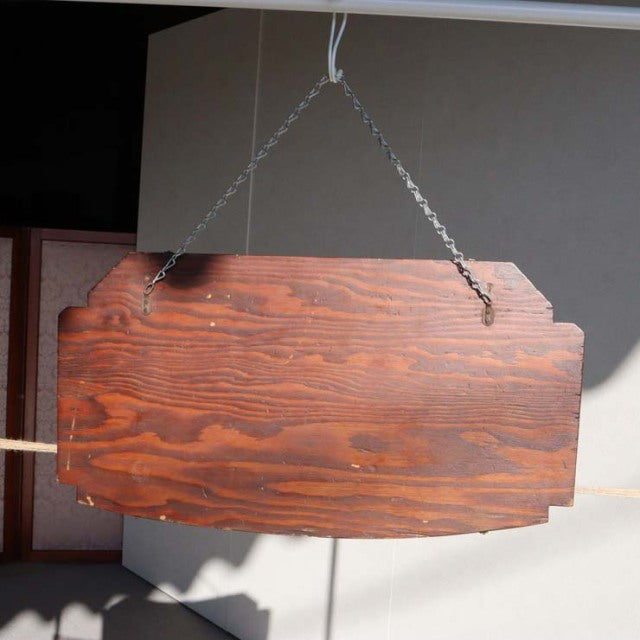 Vintage teak wood wall mirror with rich grain and scalloped top edges, British mid-century Danish design, hanging by metal.