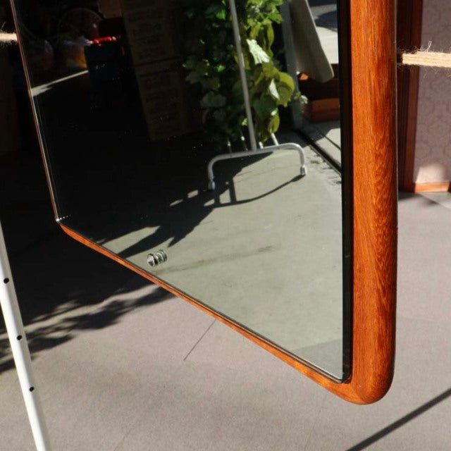 Mid-century British vintage teak wall mirror with rounded corners and rich wood grain texture.