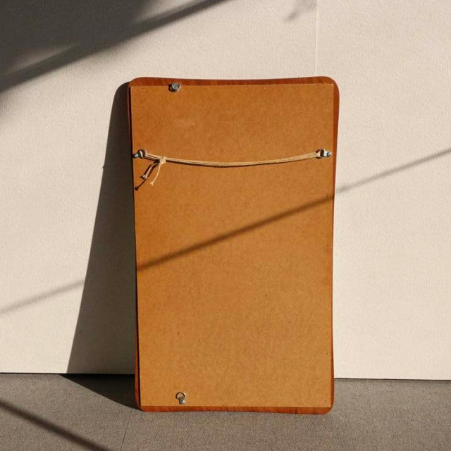 Mid-century British vintage teak wall mirror with rounded corners and visible wood grain edges, secured with metal wire.