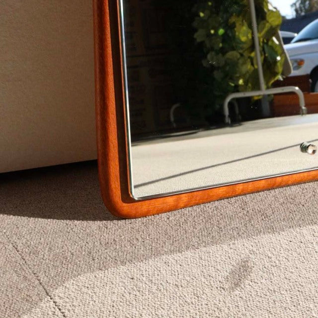 Mid-century British vintage wall mirror with rounded corners, teak wood frame showcasing warm wood grain.