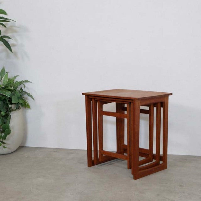 Set of three vintage teak British mid-century nest tables with clean lines and visible wood grain.