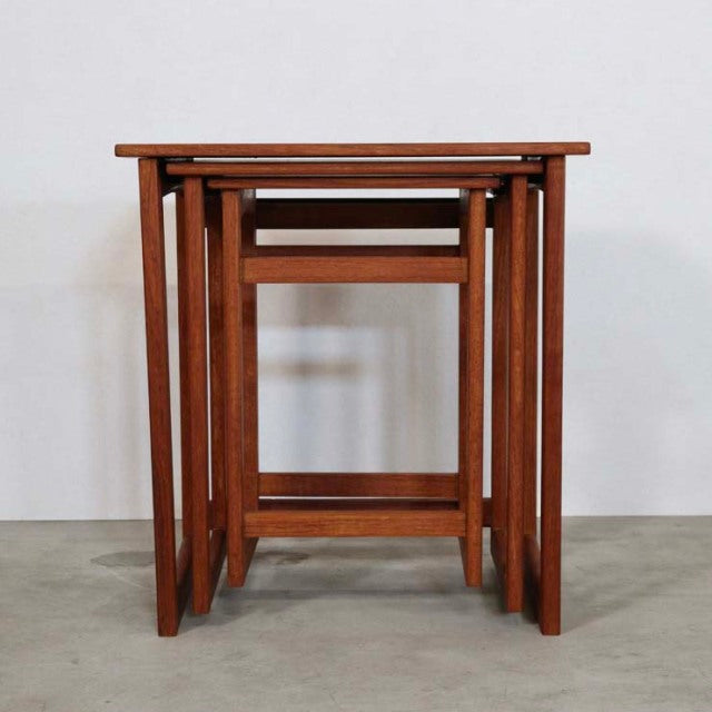 Set of three vintage teak nesting tables with clean mid-century British design, showcasing warm wood grain and slender.