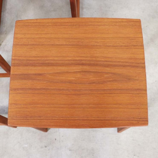 Vintage teak nesting table with smooth wood grain, rectangular top, and slender mid-century Danish legs.